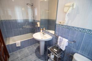 ein Badezimmer mit Waschbecken und Dusche in der Unterkunft Hotel Montero in Mondoñedo + 29 Fotos