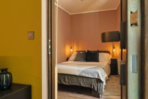 a bedroom with a bed with yellow walls at Ospitaria-Suite Sant'Anastasia in Verona