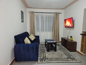 a living room with a blue couch and a table at Tawa Luxe in Meru