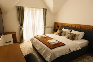a bedroom with a large bed with two towels on it at Hotel Nordik in Motički Gaj