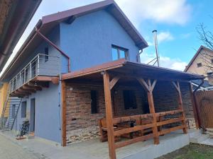 een blauw huis met een veranda en een terras bij Casa rustică săceleană in Săcele