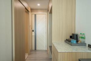eine Küche mit einer Theke und einer Tür zu einem Zimmer in der Unterkunft Enrich Grand Hotel in Bangkok