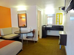 a room with a bed and a bathroom with a sink at Motel 6-Erie, PA in Erie