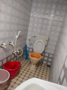 a small bathroom with a toilet and a sink at Adarsh Niwas in Malvan
