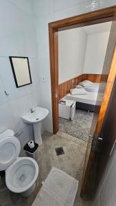 a bathroom with a toilet and a sink and a bed at Pousada Passos de Fé in Aparecida +88 photos