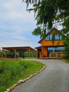 een groot houten huis op een grindweg bij PrzyStań pod Łysą Górą in Bostów