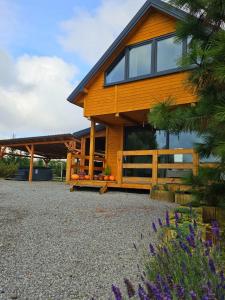 een houten huis met een hek en wat bloemen bij PrzyStań pod Łysą Górą in Bostów