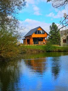 een huis naast een waterlichaam bij PrzyStań pod Łysą Górą in Bostów