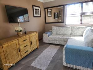 een woonkamer met een bank en een flatscreen-tv bij 18onkuruman in Summerstrand