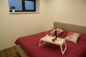 een bed met een tafel met twee glazen wijn bij Apartmány Žermanice in Horní Soběšovice