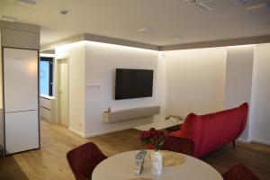 een woonkamer met een tafel en een tv aan de muur bij Apartmány Žermanice in Horní Soběšovice