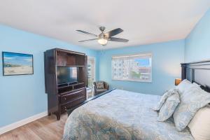 a bedroom with a bed with a ceiling fan and a tv at Beachfront Balcony Sleeps 10 Heated Pool King Bed -308 in Debikot +36 photos