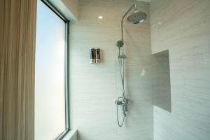 eine Dusche in einem Badezimmer mit einer Glastür in der Unterkunft Enrich Grand Hotel in Bangkok + 21 Fotos