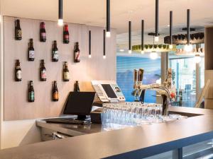 a bar with wine bottles on the wall at ibis Lausanne Centre in Lausanne