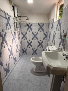 een badkamer met toilet en wastafel bij Waters meet surf villa in Weligama