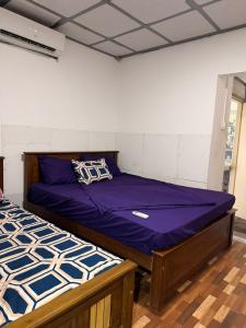 een slaapkamer met twee bedden met paarse lakens bij Waters meet surf villa in Weligama