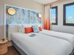 - une chambre avec 2 lits blancs et un tableau mural dans l'établissement Aparthotel Adagio Aix-en-Provence Centre, à Aix-en-Provence