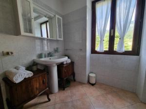 un bagno con un lavandino, uno specchio e una finestra di Lago e Monti a Zone