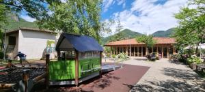 un piccolo treno verde davanti a un edificio di Lago e Monti a Zone