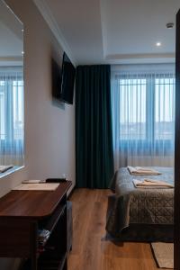 a bedroom with two beds and a desk and a mirror at Soprano Inn Hotel in Pasiky-Zubryts'ki