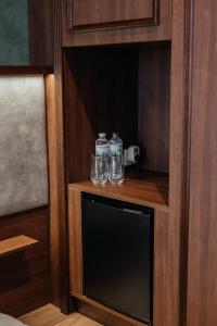two bottles of water sitting on a shelf in a room at Soprano Inn Hotel in Pasiky-Zubryts'ki