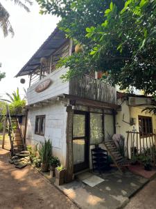 een klein huisje met een balkon erbovenop bij Waters meet surf villa in Weligama +24 foto's