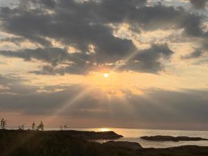 a sunset over the ocean with the sun shining at Drømmeplassen in Averoy