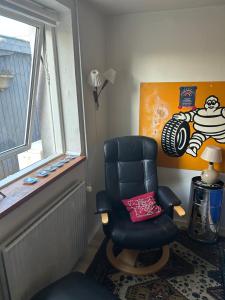 un soggiorno con una sedia e una finestra di Genbrugsfabrikkens Tiny apartment a Holbæk