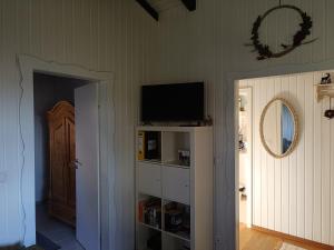 een kamer met een tv op een plank en een deur bij Ferienhaus Bärenloch in Hilders