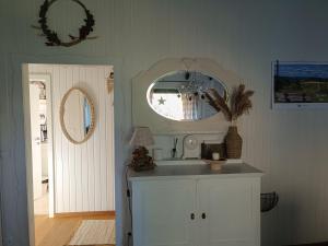 een badkamer met een witte wastafel en een spiegel bij Ferienhaus Bärenloch in Hilders