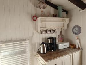 een keuken met een aanrecht met een koffiezetapparaat en een klok bij Ferienhaus Bärenloch in Hilders