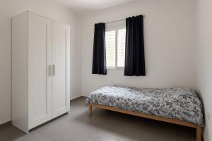 a bedroom with a bed and a window at Ocean view apart in Tel Aviv