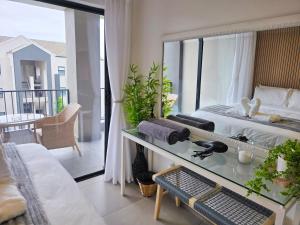 a bedroom with a bed and a view of a balcony at Luxury Spa unit, Private Sauna, Central Ballito in Ballito +16 photos