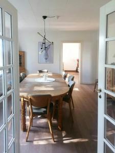 ein Esszimmer mit einem Holztisch und Stühlen in der Unterkunft Nature Gem Near Haderslev With 160-Year-Old Beech in Vedbøl