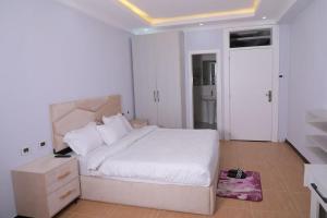 a white bedroom with a large bed and a door at Ethiopian, Addis Ababa in Addis Ababa