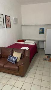 een woonkamer met een bank en een bed bij Yellow Residence in Recife