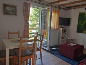 a living room with a table and chairs and a sliding glass door at Petra Kuća Apartmani Studio Divčibare Петра Кућа Апартмани Студио Дивчибаре in Divčibare +16 photos