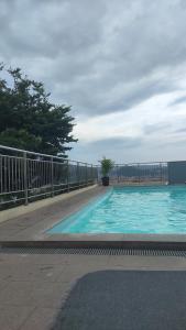a swimming pool with blue water and a fence at Denox housee in Geruntang