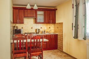 een keuken met houten kasten en een tafel en stoelen bij Apartament I Chochołów 162c in Chochołów