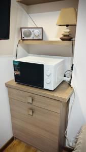 a microwave sitting on top of a wooden table at CitiMarina56 in Brodnica +8 photos