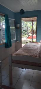 een slaapkamer met een bed met blauwe muren en een raam bij Espacio Benignia in Puerto Libertad