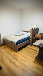 een bed in een kamer met een houten vloer bij CitiMarina56 in Brodnica