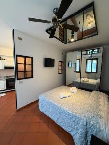 een slaapkamer met een bed en een plafondventilator bij City Flowers in Rovigo