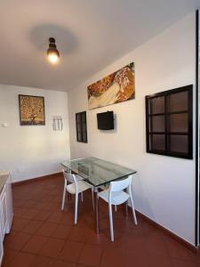 een eetkamer met een glazen tafel en 2 witte stoelen bij City Flowers in Rovigo