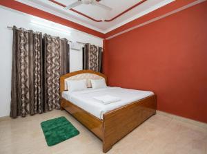 a bedroom with a bed and a red wall at Guru Amrit Residency & Guru Kripa Guest house in Ayodhya +10 photos