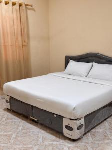 een bed in een kamer met een wit matras bij هومي Homi in Salalah