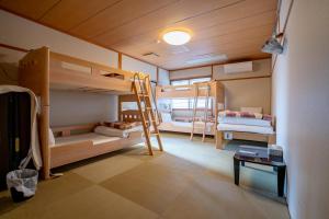 une chambre avec deux lits superposés et une table dans l'établissement Guest House Ouka, à Takayama
