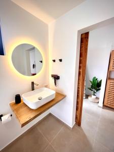 een badkamer met een wastafel en een spiegel bij The Cosy Sunset Beach Resort in Thongsala