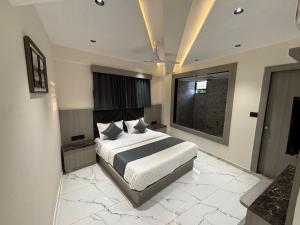 ein Schlafzimmer mit einem großen Bett und einem Fenster in der Unterkunft Hotel Prestige in Ahmedabad