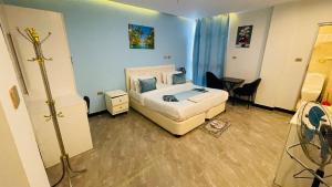 a bedroom with a bed in a room with blue walls at Solkeb Hotel in Jijiga